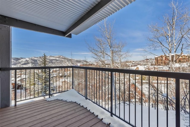 snow covered back of property featuring a mountain view