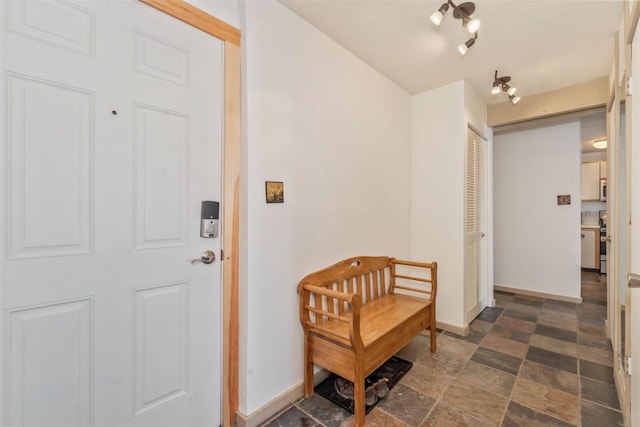 entryway with stone finish flooring and baseboards