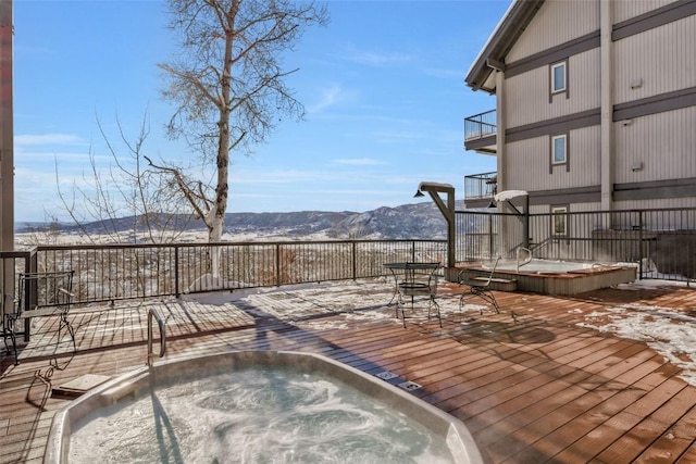 wooden terrace featuring an outdoor hot tub and a mountain view