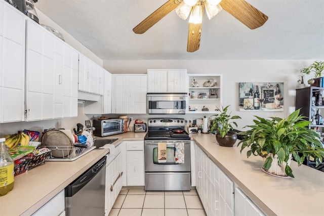 kitchen featuring ceiling fan, white cabinetry, stainless steel appliances, and light tile patterned floors