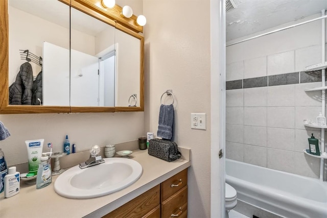 full bathroom with vanity, toilet, and tiled shower / bath