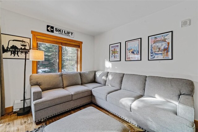 living room featuring hardwood / wood-style flooring and a baseboard heating unit