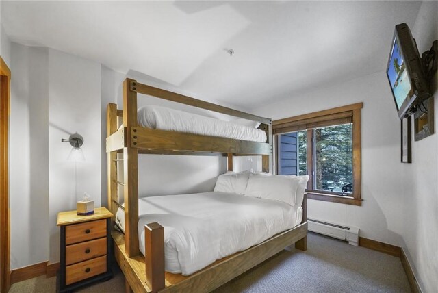 bedroom with a baseboard radiator and dark colored carpet