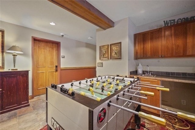 playroom with beam ceiling and sink