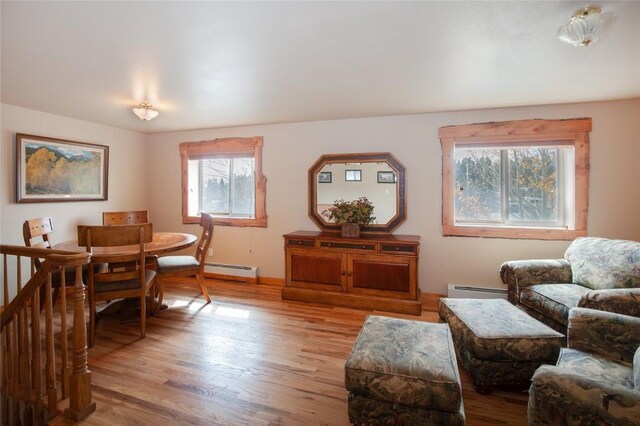 living room with baseboard heating and light hardwood / wood-style floors