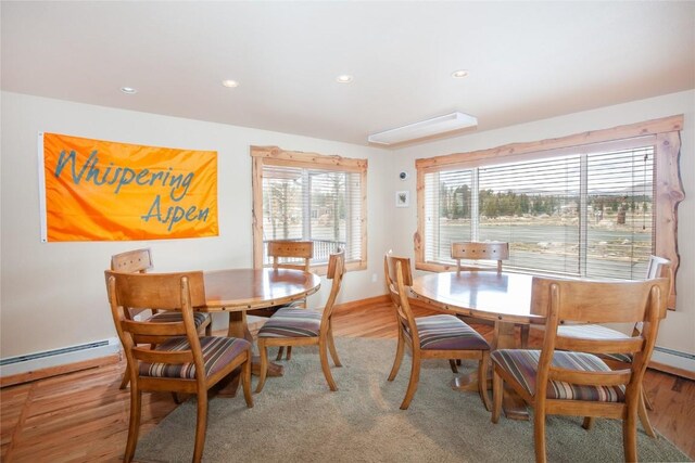 dining room with wood-type flooring and a baseboard heating unit