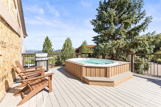 wooden deck with a hot tub and grilling area