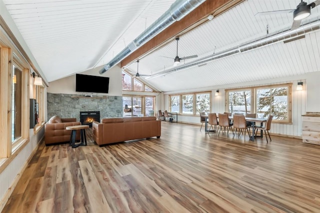 living room featuring beam ceiling, a wealth of natural light, a fireplace, and hardwood / wood-style floors