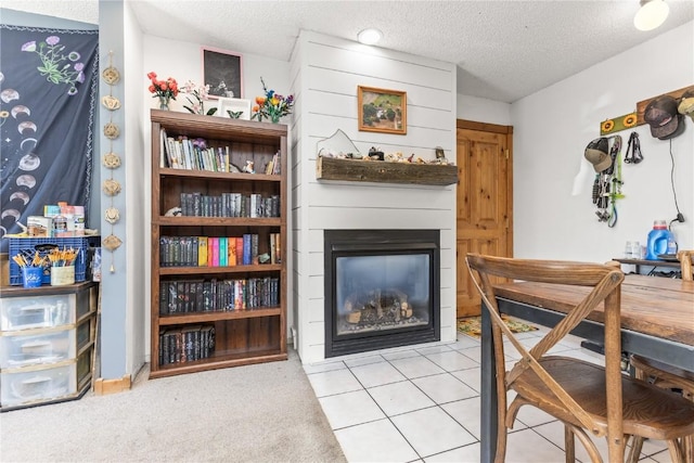 sitting room featuring a textured ceiling, light tile patterned floors, and a fireplace