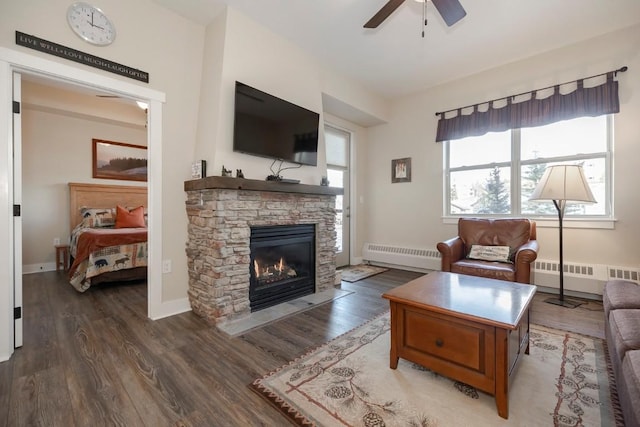 living room with ceiling fan, dark hardwood / wood-style flooring, a fireplace, and a baseboard heating unit