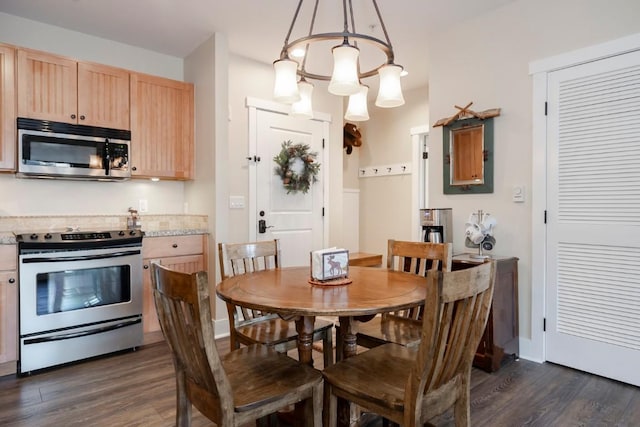 dining area with dark hardwood / wood-style flooring and an inviting chandelier