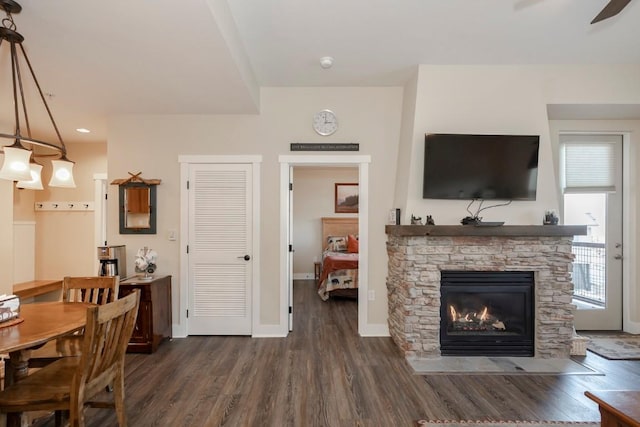 interior space with dark hardwood / wood-style floors, ceiling fan, and a fireplace