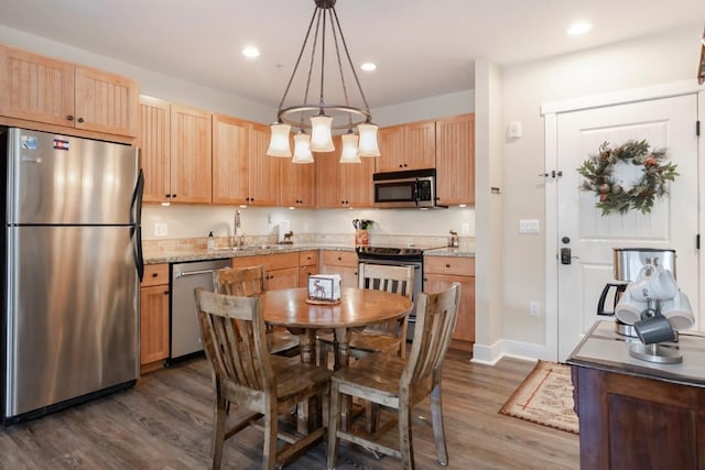 kitchen with dark wood-type flooring, sink, pendant lighting, and appliances with stainless steel finishes