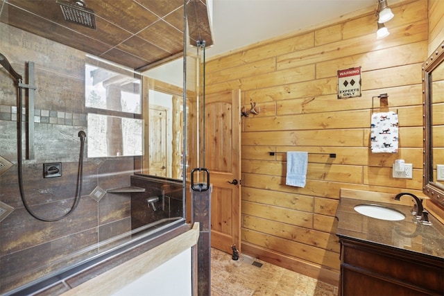 bathroom with vanity, wood walls, and tiled shower