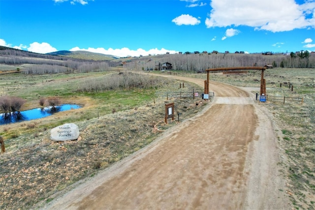 exterior space featuring a water and mountain view and a rural view