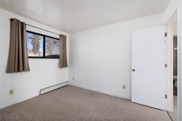 unfurnished room with a baseboard heating unit and carpet