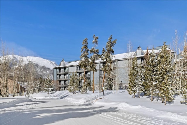 snow covered building featuring a mountain view