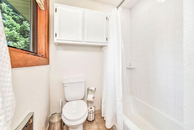 bathroom with tile patterned flooring, shower / tub combo, and toilet