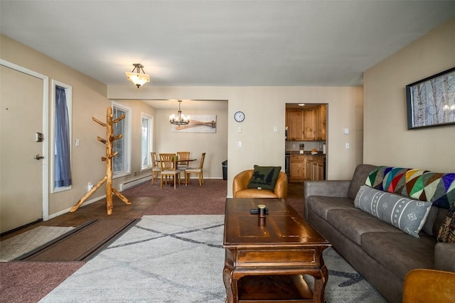 living area with a baseboard radiator, baseboards, carpet, and an inviting chandelier