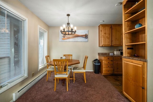 dining area with a baseboard heating unit, baseboards, a chandelier, and dark carpet