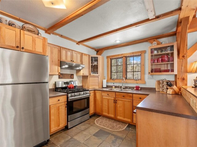 kitchen with light brown cabinetry, sink, beamed ceiling, and stainless steel appliances