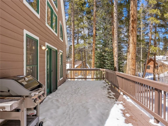 snow covered deck with a grill