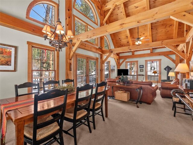 carpeted dining room with french doors, ceiling fan with notable chandelier, beam ceiling, high vaulted ceiling, and wooden ceiling