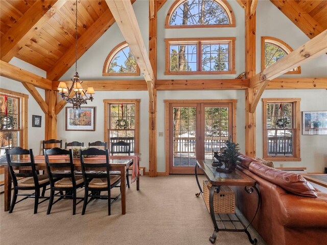 dining space featuring a chandelier, beam ceiling, light colored carpet, and high vaulted ceiling