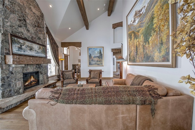 living room featuring beamed ceiling, a stone fireplace, high vaulted ceiling, and light hardwood / wood-style flooring