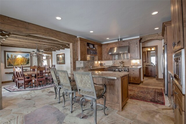 kitchen with kitchen peninsula, backsplash, stainless steel appliances, extractor fan, and beam ceiling