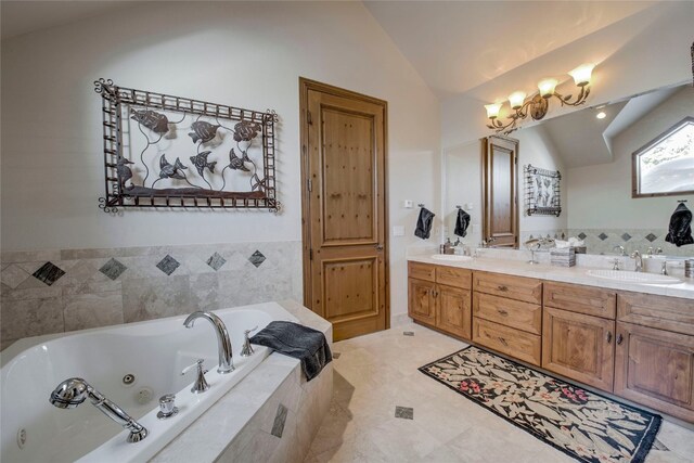 bathroom with vanity, a relaxing tiled tub, and lofted ceiling