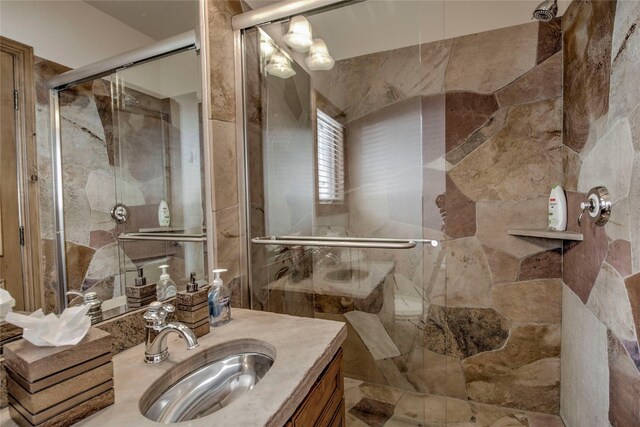 bathroom with vanity and a shower with door