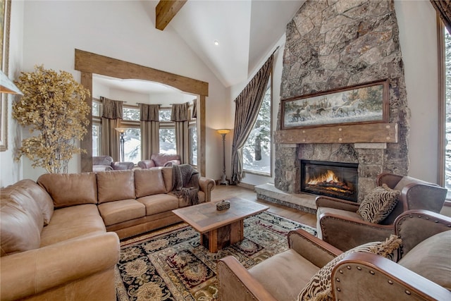 living room featuring beam ceiling, a fireplace, and high vaulted ceiling