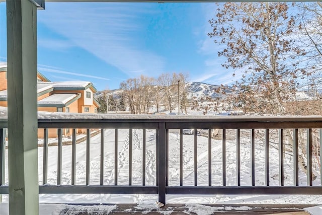 snow covered deck with a mountain view