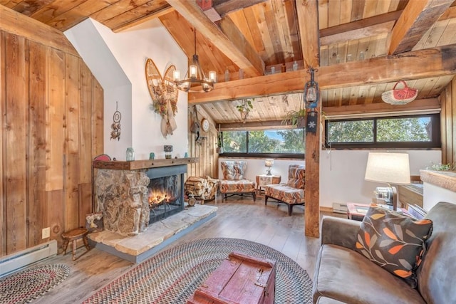 living room with a stone fireplace, wooden walls, lofted ceiling with beams, a baseboard heating unit, and light hardwood / wood-style flooring