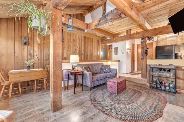 living room with hardwood / wood-style flooring, beam ceiling, wood ceiling, and wood walls