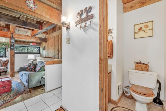 bathroom featuring tile patterned flooring, beam ceiling, and toilet