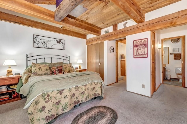 carpeted bedroom with wood ceiling, ensuite bathroom, beam ceiling, and a closet