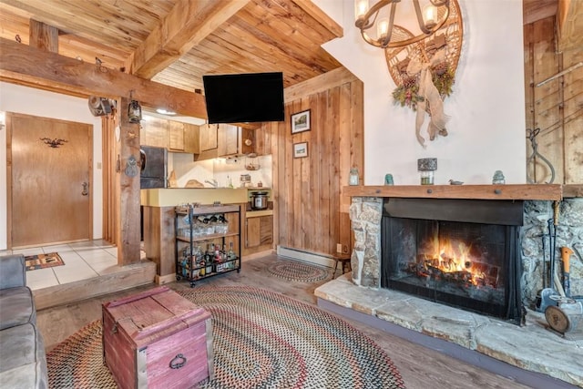 living room with wood ceiling, a baseboard radiator, wooden walls, beamed ceiling, and a fireplace