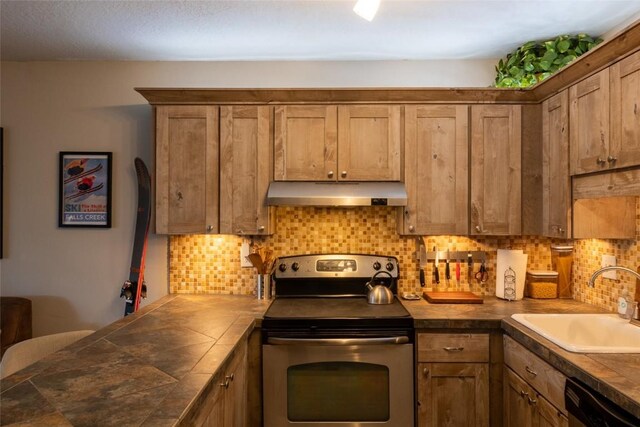 kitchen with stainless steel range with electric stovetop, sink, decorative backsplash, black dishwasher, and tile counters