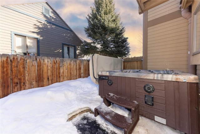 yard layered in snow with a hot tub