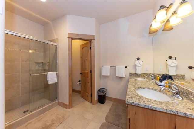 bathroom with a shower with shower door, tile patterned floors, and vanity