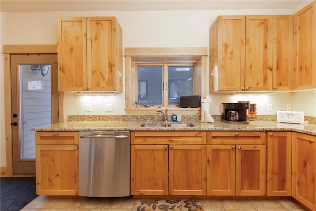 kitchen featuring light tile patterned floors, dishwasher, sink, and light stone counters