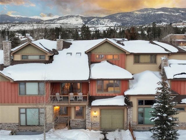 view of front of home with a garage, a mountain view, and a balcony