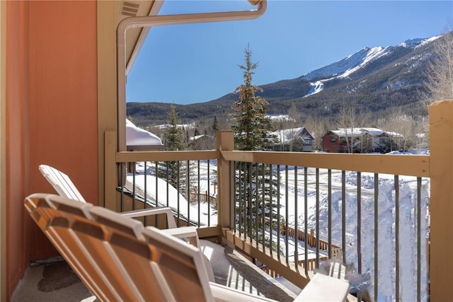 snow covered back of property with a mountain view