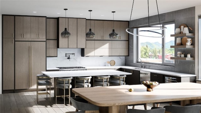 kitchen featuring a mountain view, sink, light wood-type flooring, appliances with stainless steel finishes, and tasteful backsplash