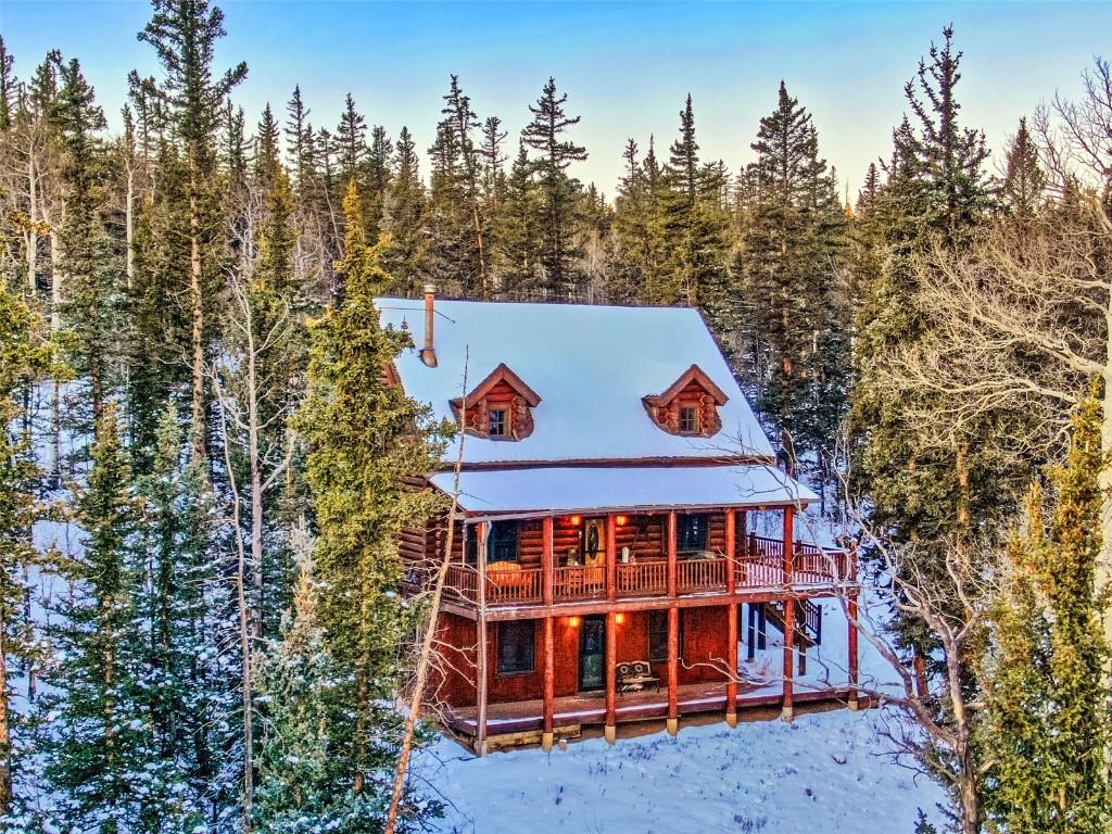 snow covered back of property featuring a wooden deck