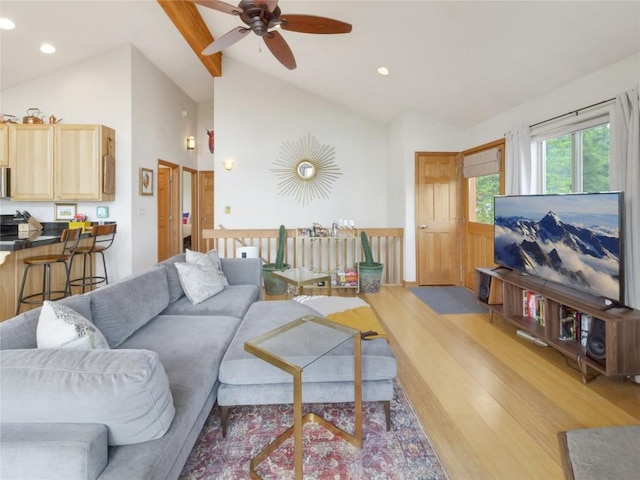 living room featuring beam ceiling, ceiling fan, light hardwood / wood-style flooring, and high vaulted ceiling