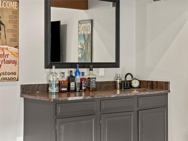 bar featuring gray cabinets and sink