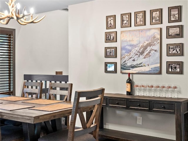 dining space featuring wood-type flooring and an inviting chandelier